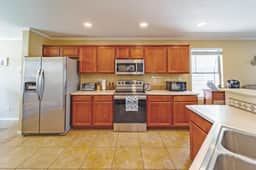 Spacious kitchen with stainless appliances, ample storage, and bar seating