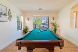 Game room with pool table, natural light, and room for friendly competition.