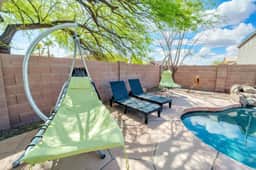 Private pool oasis with hanging loungers, sunbeds, and shaded patio