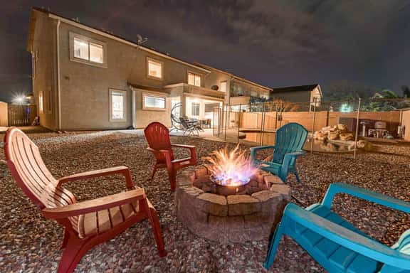 Enjoy relaxing evenings by the fire pit with colorful outdoor seating and a private backyard setting.