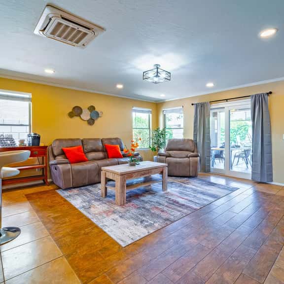 Sunny living room with recliners, coffee bar, and patio doors
