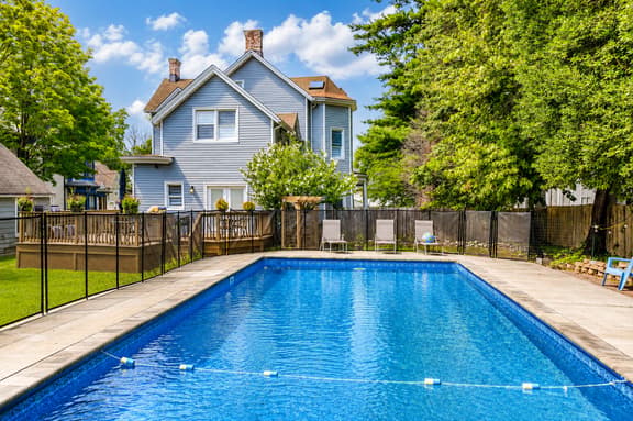 Large private pool with fenced yard, deck, and charming backyard views